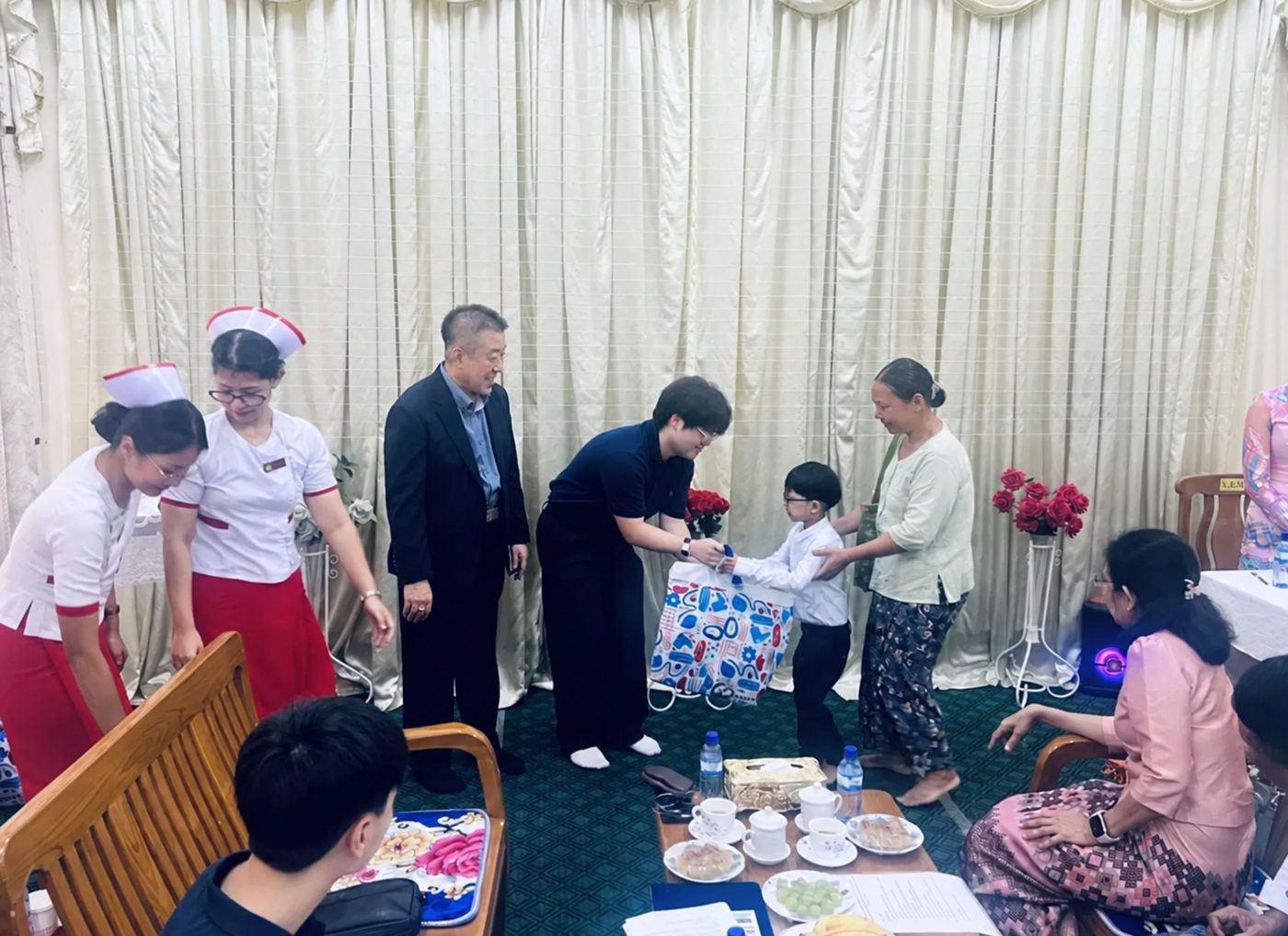 Handing a gift to a child and his family